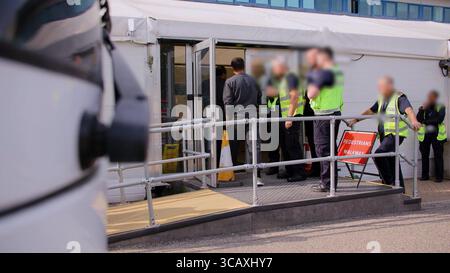 NOTE DE LA RÉDACTION - LES IMAGES SONT FLOUES À LA SOURCE. Capture d'écran tirée d'une vidéo publiée par le Home Office of Border Force Officers traitant les premiers migrants par bateau détenus dans le cadre du nouveau contrat « One in, One out » du Royaume-Uni, au Centre de traitement des demandes d'immigration de Manston, dans le Kent. Les migrants, qui ont été détenus le jour où le projet pilote a commencé à fonctionner, passent par les premières étapes du processus pilote de retour Royaume-Uni-France au cours des dernières 24 heures, y compris le traitement initial, les contrôles biométriques et de sécurité, et la réinstallation au Centre de renvoi de l'immigration pour attendre leur retour en France. Image Banque D'Images