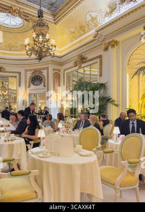 Les gens apprécient le célèbre thé de l'après-midi dans l'opulent Palm court du Ritz, un hôtel cinq étoiles de luxe à Londres, au Royaume-Uni. Banque D'Images