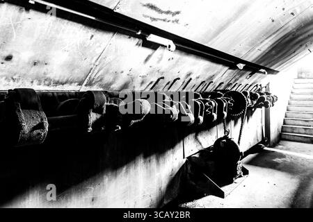 Machines industrielles rouillées dans une papeterie allemande abandonnée avec une lumière et des ombres dramatiques Banque D'Images