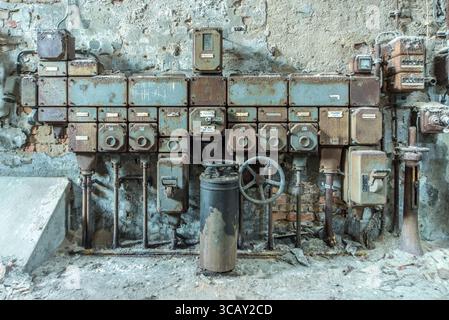 Panneau de commande industriel rouillé dans une papeterie abandonnée avec décomposition et atmosphère d'exploration urbaine Banque D'Images