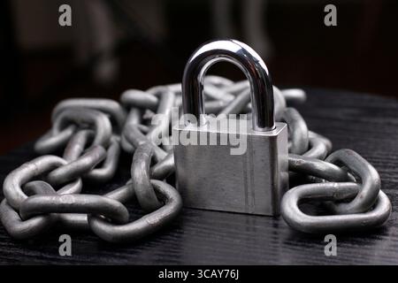 Cadenas et chaîne argentés sur fond sombre. Banque D'Images