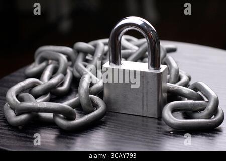 Cadenas et chaîne argentés sur fond sombre. Banque D'Images