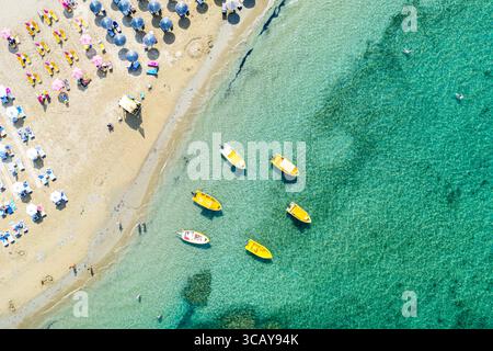 Vue aérienne drone des bateaux et de la plage avec parasols de paille à l'eau turquoise. Mer Ionienne, île de Céphalonie, Grèce Banque D'Images