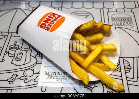 Marilia, SP, Brésil, 29 mai 2025. Frites Burger King renversées dans un sac de papier blanc sur fond de napperon illustré, mettant en valeur le son de restauration rapide Banque D'Images