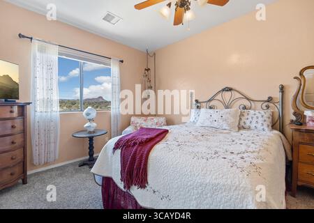 Une chambre confortable avec un lit confortable, une commode élégante, un miroir fonctionnel et une télévision de divertissement pour la détente et le plaisir Banque D'Images