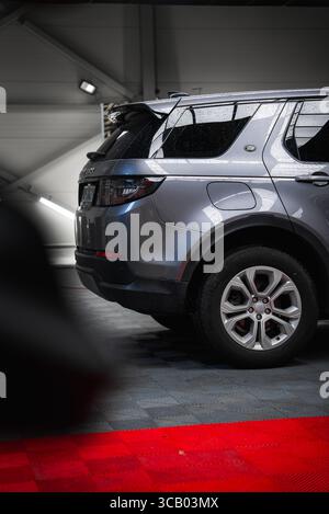 Vue arrière du Range Rover Discovery argenté dans un garage moderne Banque D'Images