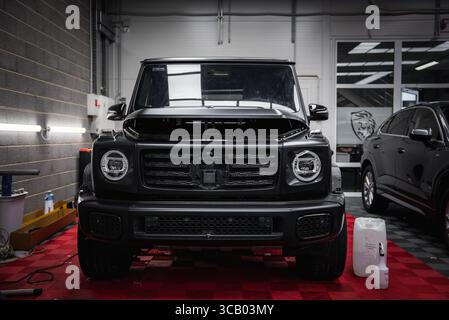 Noir Mercedes classe G SUV avec capot ouvert dans le garage du magasin de voitures Banque D'Images