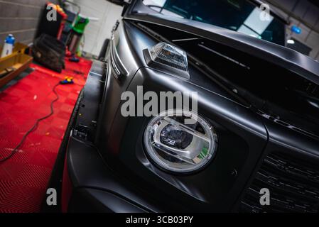 Gros plan du SUV Mercedes classe G noir dans un garage de magasin de voitures Banque D'Images
