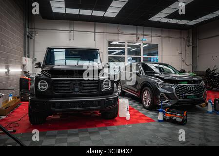 Mercedes classe G noire et Audi SUV gris dans un garage moderne Banque D'Images