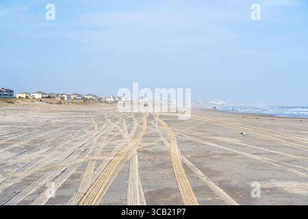 Grande plage avec des traces de pneus dans le sable des véhicules à quatre roues motrices Banque D'Images