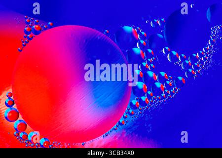 Macro shot de bulles d'huile avec de l'eau sur fond coloré. Espace et univers planètes style abstrait image. Banque D'Images