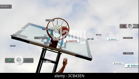 Basket-ball tombant à travers le filet de cerceau tandis que le bras atteignant sur le terrain extérieur avec recouvrement numérique Banque D'Images