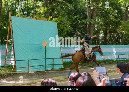 Un archer expérimenté exécute Yabusame, une démonstration traditionnelle japonaise de tir à l'arc à cheval pendant le festival Yabusame Shinji, visant des cibles en A. Banque D'Images