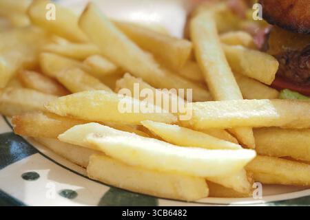 Frites dorées servies sur une assiette avec garnitures Banque D'Images