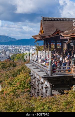 Foules de touristes sur la scène historique au temple bouddhiste Kiyomizu-dera sur une terrasse surélevée, entouré par le feuillage d'automne vibrant, Kyoto, Japon Banque D'Images