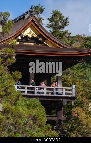 Scène historique au temple bouddhiste Kiyomizu-dera Kyoto entouré d'arbres luxuriants, avec les visiteurs admirant la vue panoramique depuis sa plate-forme surélevée. Banque D'Images