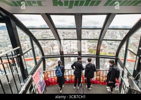 Les visiteurs profitent d'une vue panoramique sur le paysage urbain de Kyoto depuis la terrasse d'observation Nidec Kyoto Tower, avec des environnements urbains et des montagnes lointaines Banque D'Images