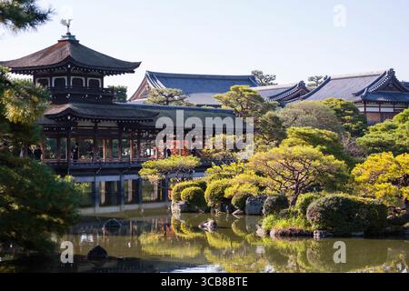 Heian Jingu Taiheikaku Pavillon entouré d'une végétation luxuriante et d'un étang réfléchissant tranquille, incarnant l'architecture traditionnelle et l'être naturel paisible Banque D'Images