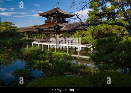 Pavillon Heian Jingu Taiheikaku entouré d'une végétation luxuriante et d'un étang réfléchissant. Capture l'essence de l'architecture culturelle et de la beauté naturelle dans Banque D'Images