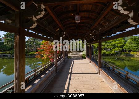 Heian Jingu Taiheikaku Pavillon dans un jardin japonais serein, entouré d'une végétation luxuriante et une vue sur l'eau plate, créant un cadre tranquille et harmonieux Banque D'Images