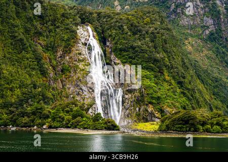 Lady Bowen Falls et la plage de Milford Sound, Fiordland National Park, Southland, South Island, Nouvelle-Zélande Banque D'Images