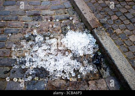 Cubes de glace jetés sur la rue pavée en train de fondre à Copenhague, Danemark Banque D'Images