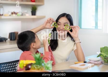 Cuisine ludique : mère et fils s'amusant avec des formes de légumes Banque D'Images