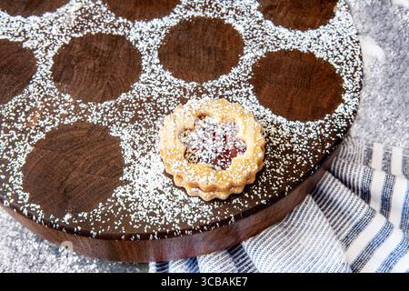 USA : gros plan d'un cookie Linzer saupoudré de sucre en poudre sur une planche de bois ronde (crédit image : © Novo images/Glasshouse via ZUMA Press Wire) Banque D'Images