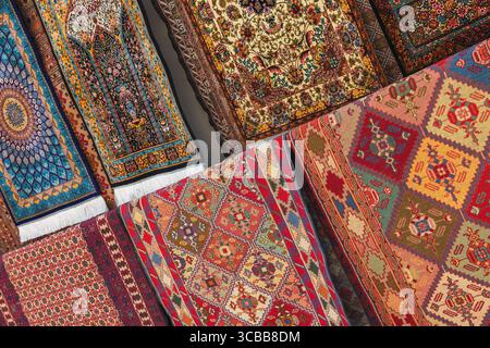 Tapis colorés faits à la main disposés symétriquement, mettant en valeur des motifs complexes et un savoir-faire traditionnel. Un affichage éclatant de l'art du tissage et du Cu Banque D'Images