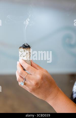 Femme tenant Smudge Stick de sauge avec de la fumée à Punta Gorda, Floride Banque D'Images