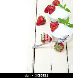 Yaourt grec biologique et fraise sur table en bois rustique blanc Banque D'Images