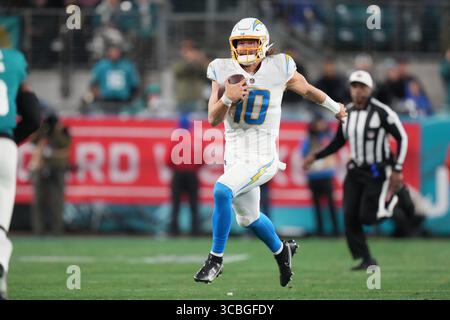 14 janvier 2023, Jacksonville, Floride, États-Unis : le quarterback Justin Herbert (10 ans) des Los Angeles Chargers se bat pour un énorme gain lors du match des séries éliminatoires entre les Los Angeles Chargers et les Jacksonville Jaguars, samedi 14 janvier 2023 au TIAA Bank Field à Jacksonville, Floride (crédit image : © Peter Joneleit/ZUMA Press Wire) Banque D'Images