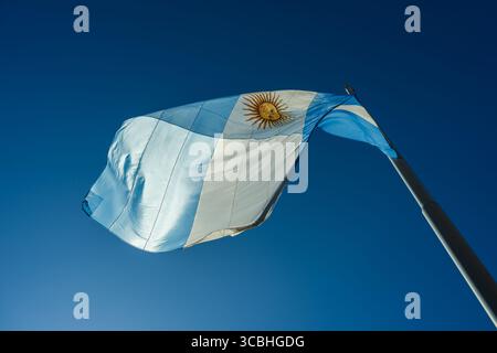 Le drapeau national de l'argentine agite fièrement dans le vent contre un ciel bleu éclatant Banque D'Images