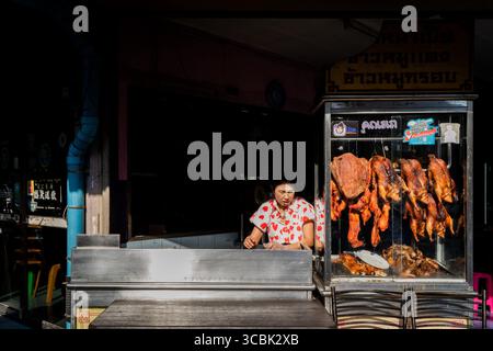 14 février 2023, Bangkok, Thaïlande : une vendeuse de nourriture de rue portant une blouse avec des coeurs de Saint-Valentin prépare son stand pour les clients dans le soleil de l'après-midi. (Crédit image : © Matt Hunt/ZUMA Press Wire) Banque D'Images