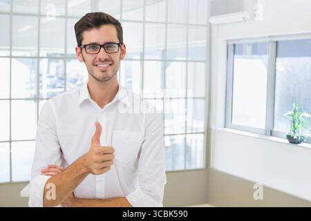 Employé de bureau masculin debout derrière la cloison de verre dans le bureau portant des lunettes et chemise blanche. Professionnel, entreprise, moderne, travail d'équipe, succès, p Banque D'Images