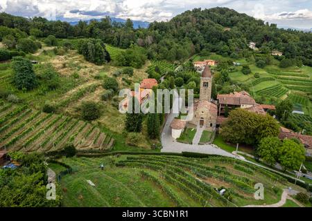 Drone vue de l'abbaye de Saint Egidio, Lombardie, Italie, entouré de vignes et de collines sous ciel nuageux, parfait pour le voyage, le patrimoine, et Banque D'Images