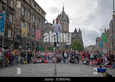 Edinburgh Festival Fringe, Royal Mile, Édimbourg, Écosse, Royaume-Uni. 8 août 2025. Journée principalement nuageuse jusqu'en fin d'après-midi pour les interprètes sur la High Street, attirant toujours de grandes foules pour leurs performances. Photo : Mike jongle sur son monocycle. Credit : Arch White/Alamy Live news Banque D'Images