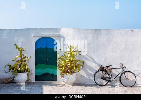 Mur avec cactus, vélo et porte à Ostuni, Apulia, Italie Banque D'Images