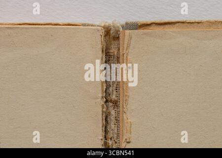 Vieux livre déchiré avec des pages blanches jaunies et une déchirure au milieu sur un fond blanc, pages de livre jaunes Banque D'Images