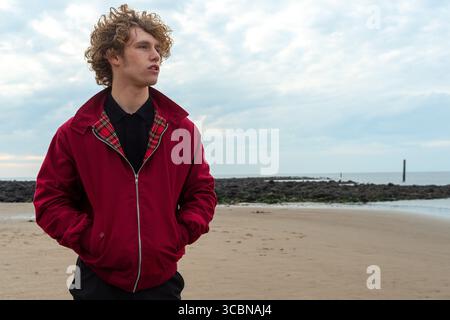 Jeune modèle masculin dans la mode Mod pose à Irvine Beach, en Écosse Banque D'Images
