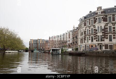 Une vue le long d'un canal à Amsterdam, Hollande montrant les maisons étroites typiques bordant le canal. Banque D'Images