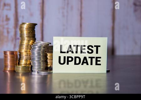 DERNIÈRE MISE À JOUR du texte avec bloc-notes, clavier, vase décoratif et stylo plume sur fond en bois. Concept d'espace d'affaires et de copie Banque D'Images