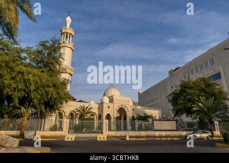 La mosquée King Hussein Bin Talal se dresse à Aqaba, en Jordanie, avec des minarets élégants et une cour vibrante reflétant la foi musulmane dans la lumière du jour chaude. Banque D'Images