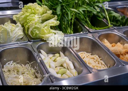 Sélection de légumes frais dans le bar à salades du restaurant, y compris laitue, chou râpé, épinards d'eau et plus encore Banque D'Images