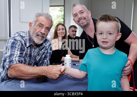 L'acteur Mel Gibson rencontre les fans Adam Walker et son fils Nathan, de Dublin, alors qu'il signe des affiches en faveur de l'Irish Equity support Fund, dans le cadre du King John's Summer Prom Festival qui marque les 30 ans du tournage de Braveheart en Irlande, au Trim Castle Hotel, Co Meath. Date de la photo : samedi 9 août 2025. Banque D'Images