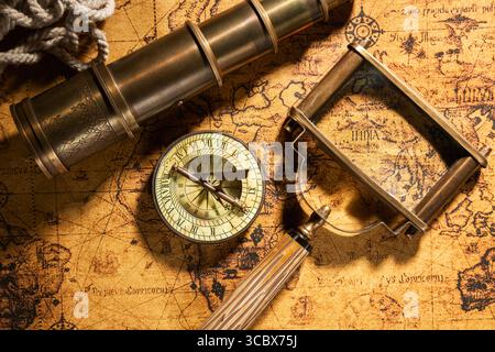 Arrière-plan géographique de voyage. Vieux spyglass, corde, boussole vintage et loupe sur la carte géographique vintage atlas du monde Banque D'Images