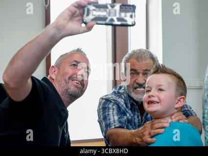 L'acteur Mel Gibson pose pour un selfie alors qu'il rencontre les fans Adam Walker et son fils Nathan, de Dublin, tout en signant des affiches en faveur de l'Irish Equity support Fund, dans le cadre du King John's Summer Prom Festival qui marque les 30 ans du tournage de Braveheart en Irlande, au Trim Castle Hotel, Co Meath. Date de la photo : samedi 9 août 2025. Banque D'Images
