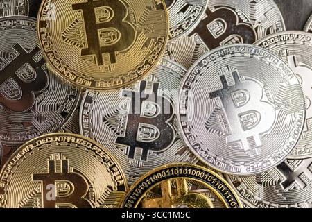 Un arrangement de pièces Bitcoin en or et en argent placées sur une surface de pierre texturée, symbolisant les concepts de crypto-monnaie et de monnaie numérique. Banque D'Images