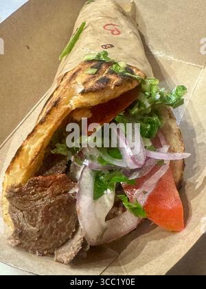 Gyroscope de bœuf grec traditionnel enveloppé dans du pain pita grillé avec des légumes frais. Banque D'Images