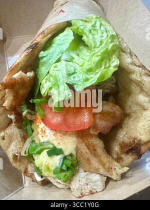 Gyro de poulet grec avec pita grillé, laitue, tomate et sauce. Banque D'Images